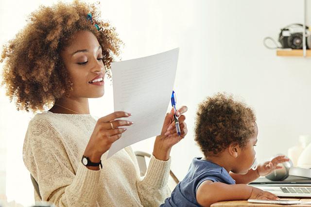 mom working on paper, baby nearby